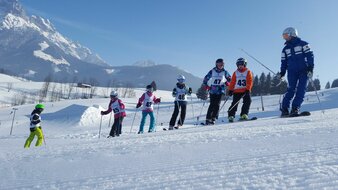 Skischule Edelweiß Skilehrerin auf der Piste mit Kindern mit Startnummern | © Skischule Edelweiß