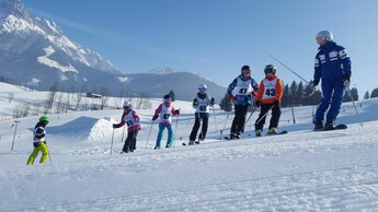 Skilehrer mit Kindergruppe mit Startnummern auf der Skipiste | © Skischule Edelweiß