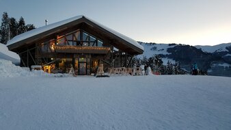 Beleuchtete und verschneite Skihütte | © Skischule Edelweiß