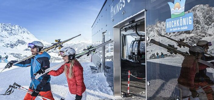 Pärchen mit Skiern auf den Schultern verlassen Liftstation | © Hochkönig Tourismus GmbH